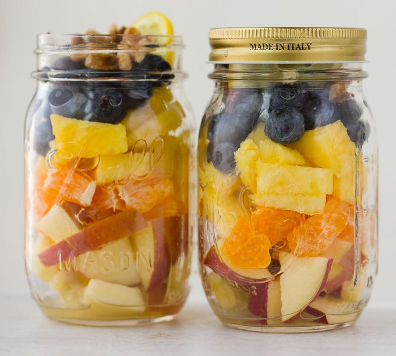 salade aux fruits dans un bocal en verre, idee picnic recette legère et facile à faire soi-mneme, ananas, pommes, tranches de mandarine et myrtilles, noix